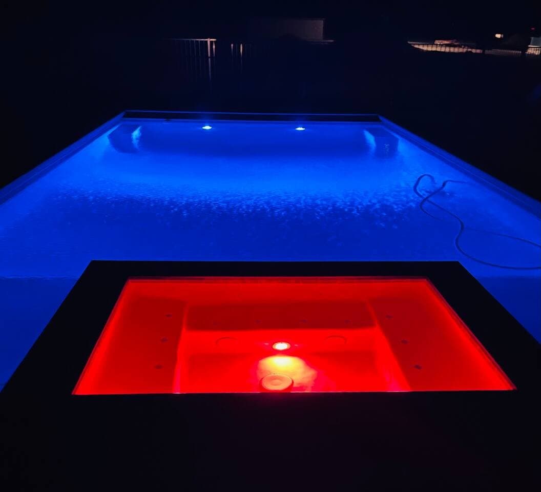 Pool and hot tub lit at night